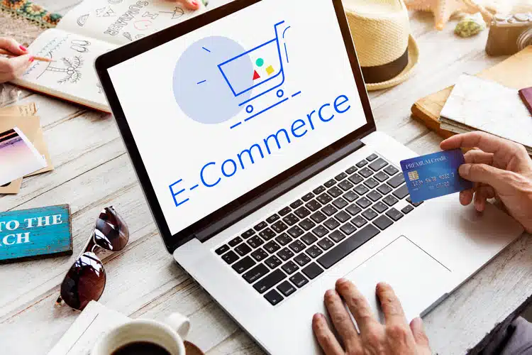 A person holding a credit card in front of a laptop, symbolizing the convenience and ease of ecommerce shopping. Ecommerce SEO can help you reach more customers and grow your online business.
